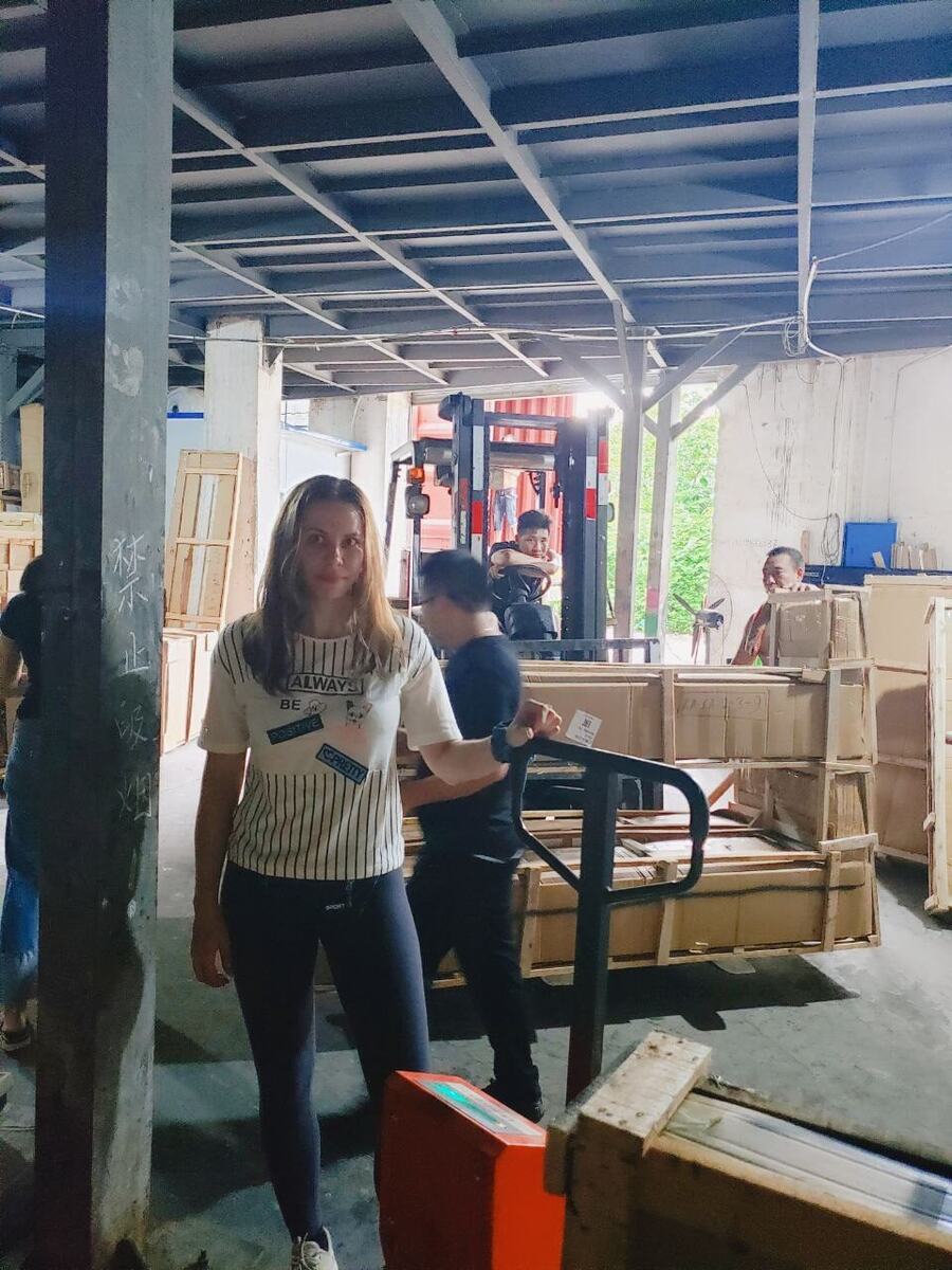 Екатерина на складе перед отгрузкой мебели: ящики, рохля, погрузчик